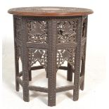 A 20th Century Anglo Indian occasional table raised on octagonal panelled supports with pierced