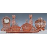 An early 20th Century Art Deco pink pressed glass dressing table set having impressed rose