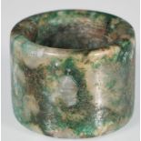 A 20th Century Chinese hard stone thumb / archery ring in a green mottled colourway. Measures 3.