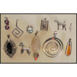 A selection of silver pendants to include two spir