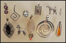 A selection of silver pendants to include two spir