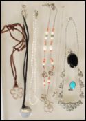 A group of silver necklaces and pendants to includ