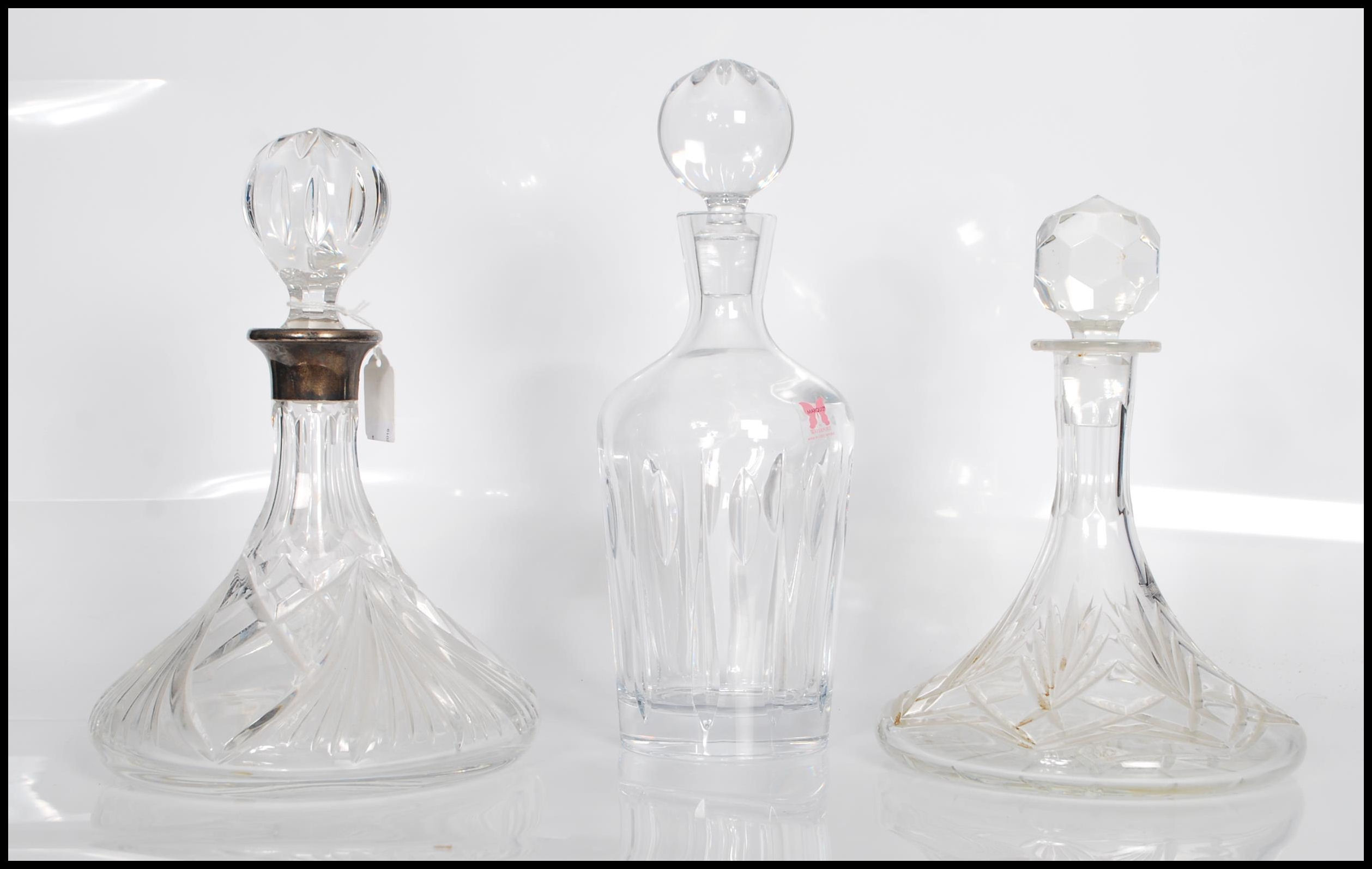 A group of three 20th Century cut glass decanters.