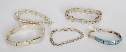 A group of five silver bracelets to include a puzz