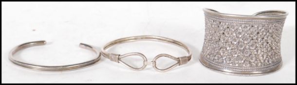 A group of three silver bangles one embossed with