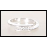 A stamped 750 18ct white gold ring of wrap around