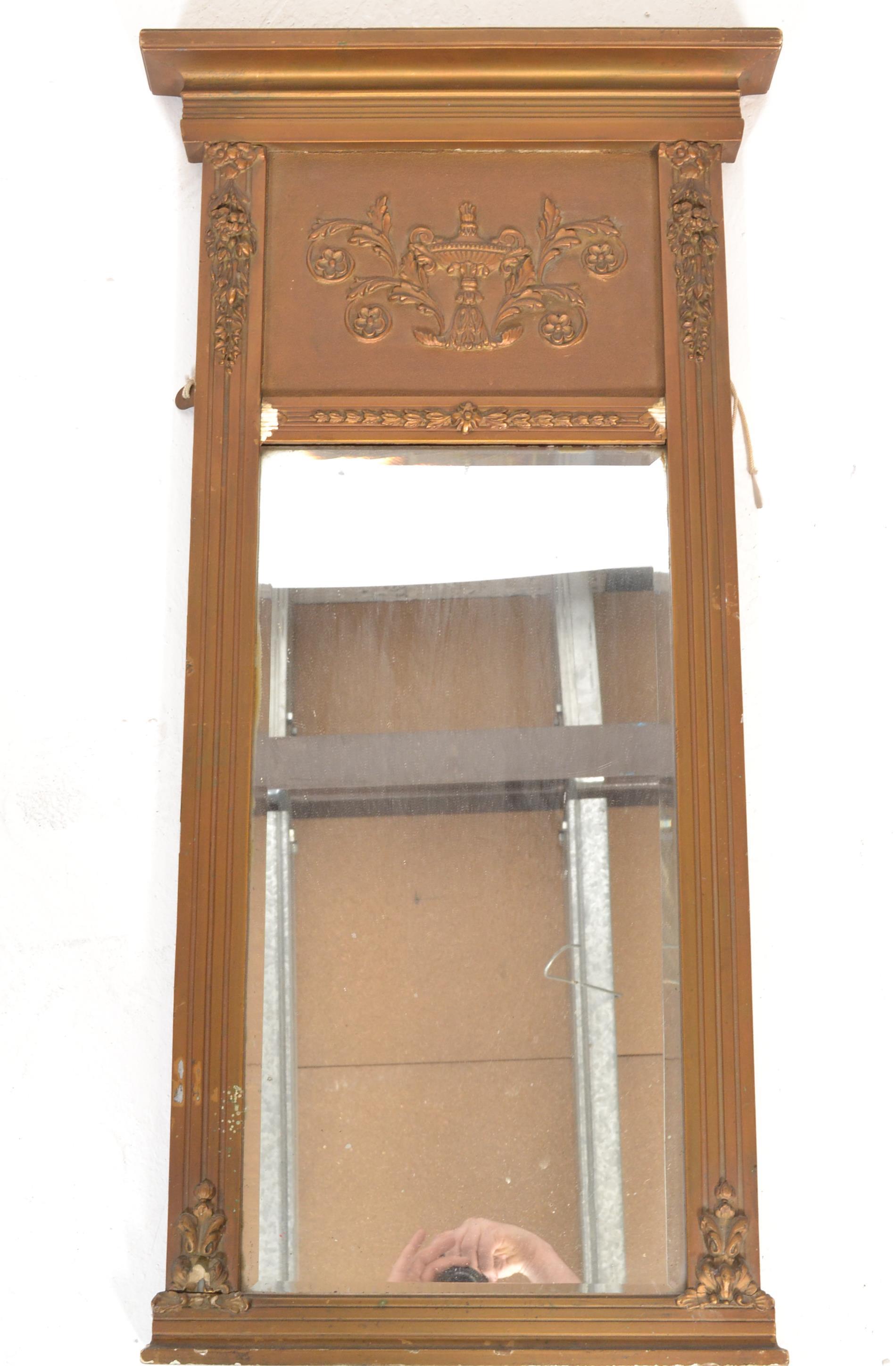 An antique style pier mirror having gilt moulded d