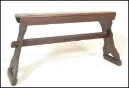 A early 20th Century stained pine bench raised on