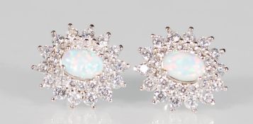 A pair of silver stud earrings set with central op