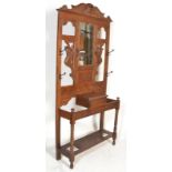 A 19th Century Victorian carved oak hall stand, raised bevel edge mirror back over glove box