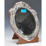 An early 20th Century silver mounted Art Nouveau shield shaped easel mirror having embossed silver
