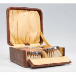 A silver plated and pink  guilloche enamel cased three-piece dressing table / brush set consisting
