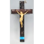 An early 20th Century antique blackthorn wooden crucifix having a carved ivorine Christ with