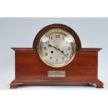 A 1930's Art Deco walnut 8 day mantel clock having inset silvered dial over silver hallmarked