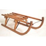 A vintage 20th Century Davos Germina wooden toboggan / sled having metal runners. Measures 24cm high