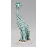 A 20th century continental Herend figure of a giraffe being stamped to the foot in a green and white