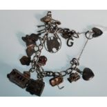A silver hallmarked vintage 20th Century charm bracelet having several charms to include a church, a