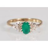 An English hallmarked 9ct gold ring set with an oval cut green stone flanked by ten round cut