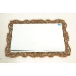 A vintage 20th Century decorative gilt framed mirror of priced scroll decoration having a