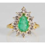 An unmarked but tests as 9ct yellow gold ring set with a central cut green glass stone with a halo