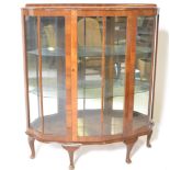A 1930's Art Deco walnut china display cabinet. Raised on cabriole legs with pad feet supporting a
