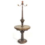 A vintage 20th Century carved standard lamp occasional table, circular base with turned baluster