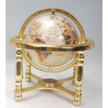 A vintage style lapis lazuli desk top globe having brass mounts with inset semi precious stones on a