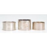 A group of three 20th Century silver hallmarked napkin rings to include an engine turned napkin ring
