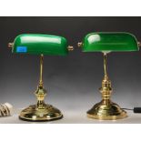 A non matching pair of vintage 20th Century Bankers lamps raised on gilt brass circular bases with