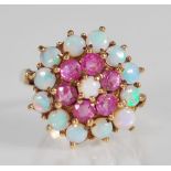 A hallmarked 9ct gold ruby and opal cluster ring. The ring being set with a central opal