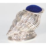 A stamped 925 silver pin cushion in the form of a conch shell raised on a footed base with a blue