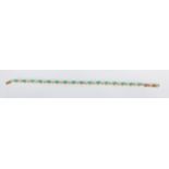 A 20th Century tennis bracelet set with marquise cut green stones and alternate white stone spacers.