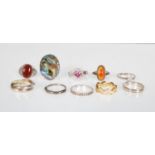 A collection of silver rings to include an oval panel ring set with abalone, a pink and white