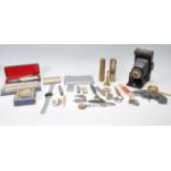 A collection of miscellaneous items to include a folding Kodak camera, trench art shell lighter,
