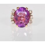 An 18ct gold ladies dress ring set with a larve oval cut amethyst flanked by six round cut diamond