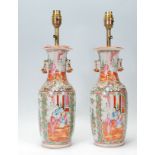 A pair of 19th Century Cantonese ceramic table lamps of baluster form hand painted panels