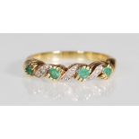 An English hallmarked 9ct gold ring having a twist design set with four round cut green stones