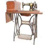 A late 19th century mahogany and cast iron singer sewing machine table. Raised on cast iron