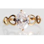 A stamped 9ct gold ladies ring set with an oval cut white stone with pierced decoration heart design