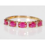 A 9ct gold ruby and diamond dress ring,the ring set with five red stones interspersed with diamonds.