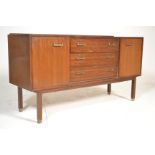 A retro mid century teak wood G-Plan sideboard credenza being raised on tapering legs with end