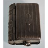 A vintage silver white metal vesta / sovereign case in the form of a book. The spring hinged front