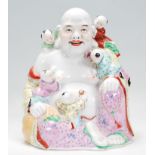An early to mid 20th century Chinese laughing buddha in the seated lotus position with children
