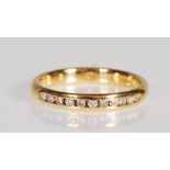 An English hallmarked 18ct gold ring channel set with round cut white stones. Assay marked