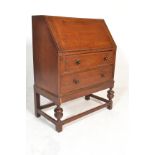A 1930's Art Deco oak bureau desk. Raised on cup and cover supports united by peripheral