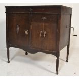 An early 20th century oak cased gramophone cabinet raised on squared legs with speaker doors to