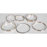 A group of six stamped 925 silver bangle bracelets to include a mother of pearl inlaid spacer