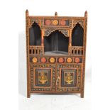 A 20th Century Swiss style painted wall hanging corner cabinet on black ground, hand decorated