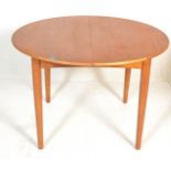 A retro 20th Century Danish inspired teak wood circular extendable dining table, the circular dining