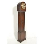 A 1930's Art Deco oak cased grandmother clock, the oak trunk with dome top over silvered dial and